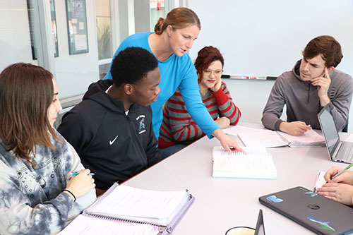 Employee helping a group of students