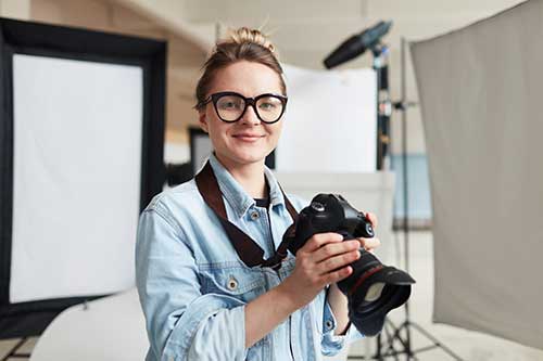 Photographer holding a camera in a photography studio