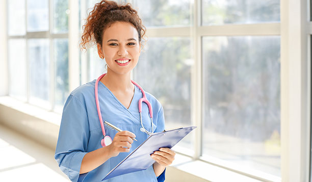 Nurse wearing a pink stethescope and holding a clipboard